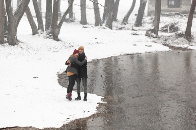 Young couple hugging next to a river