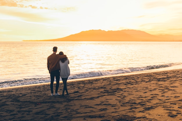 Free Photo young couple hugging on sea shore 