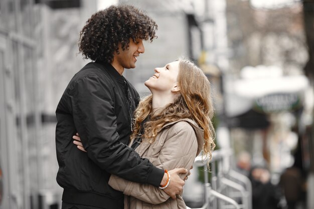 Young Couple hugging in the street wearing coats.