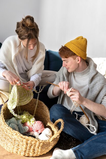 Young couple knitting together