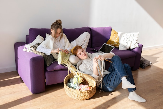 Young couple knitting together