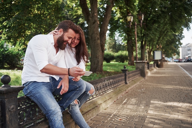 Young couple looking at a smartphone on a sunny day in the city