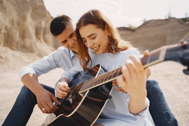 Young couple in love, boyfriend playing the guitar