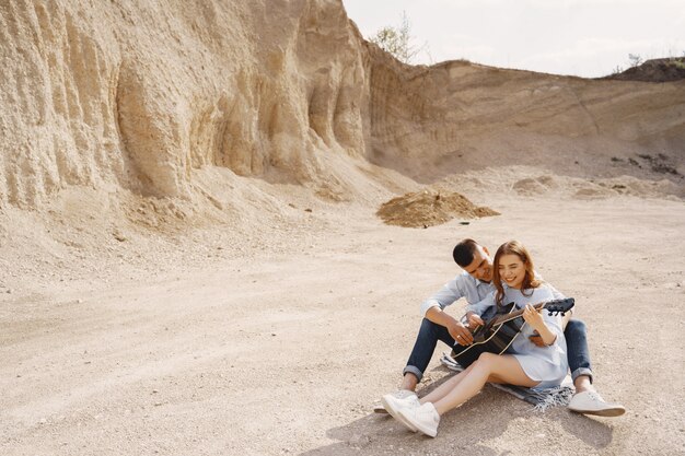 Young couple in love, boyfriend playing the guitar