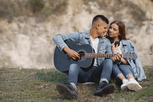 Young couple in love, boyfriend playing the guitar