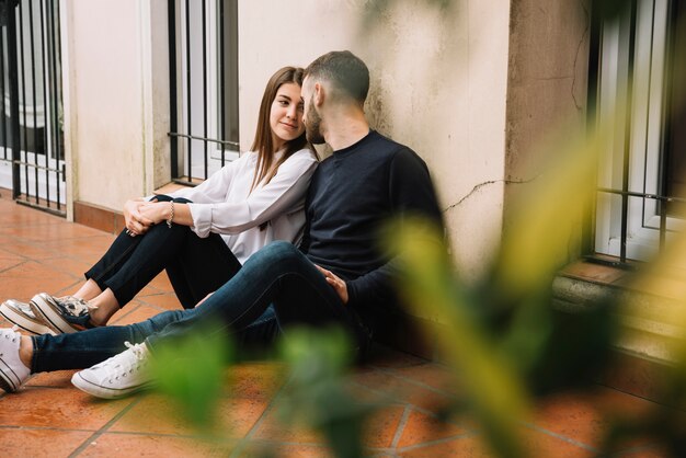 Young couple in love leaning against house