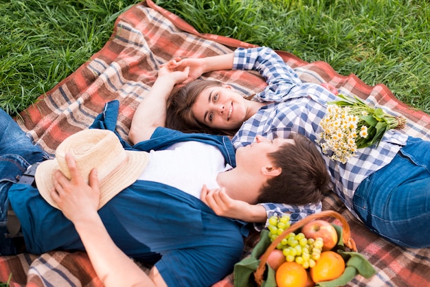 Free photo young couple in love lying together on blanket