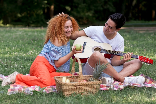 Free photo young couple in love on picnic blanket