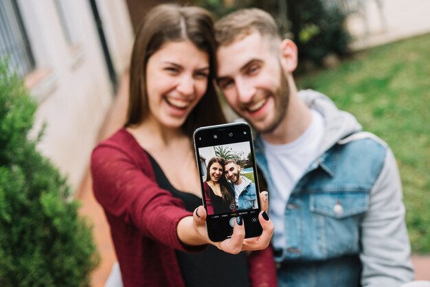 Young couple in love taking selfie in garden