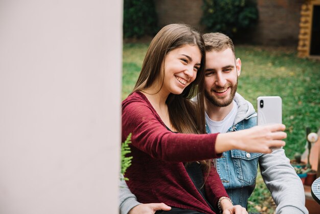 Young couple in love taking selfie in garden