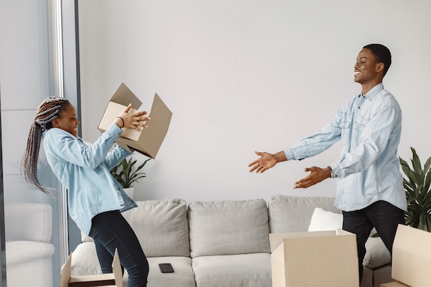 Young couple moving in to new home together. African american couple with cardboard boxes.