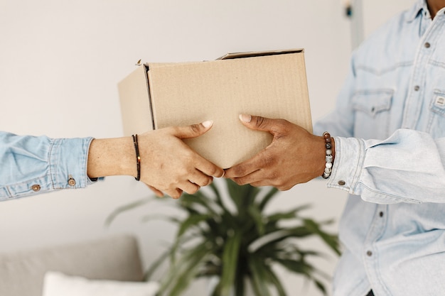 Young couple moving in to new home together. African american couple with cardboard boxes.