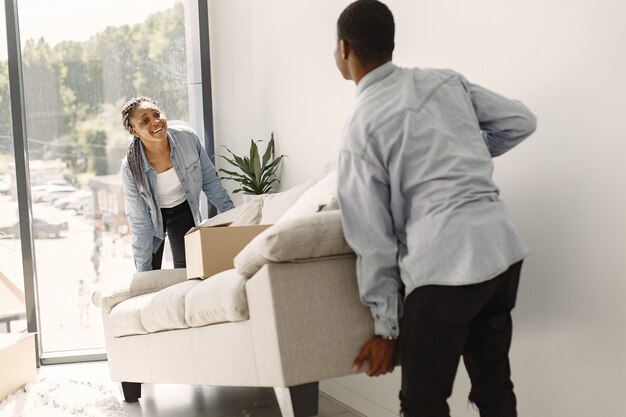 Young couple moving in to new home together. African american couple with cardboard boxes.