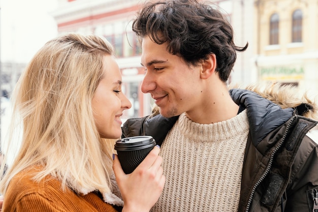 Free photo young couple outdoor enjoying cup of coffee