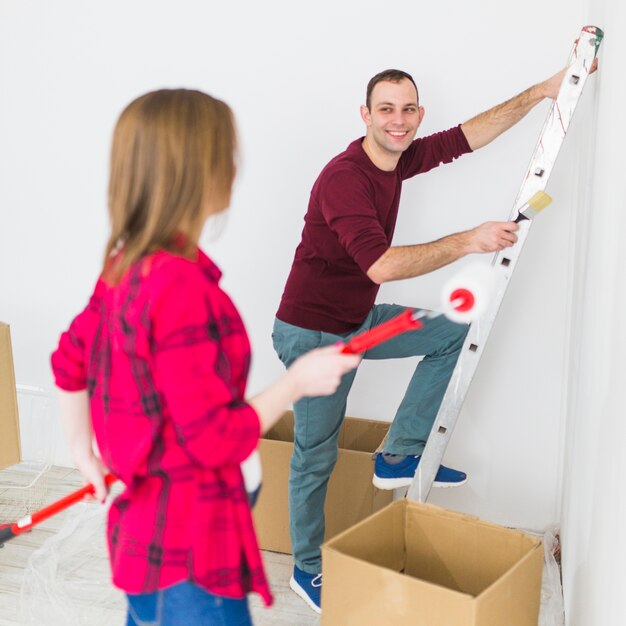 Young couple painting walls and smiling