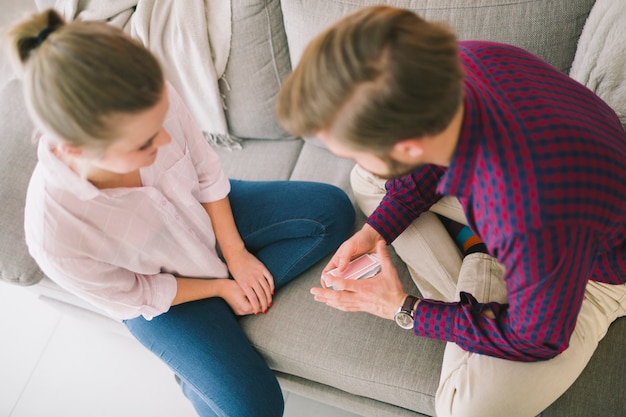 Young couple playing cards on sofa