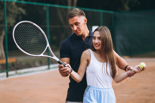 Young couple playing tennis at the court