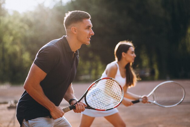 Young couple playing tennis at the court