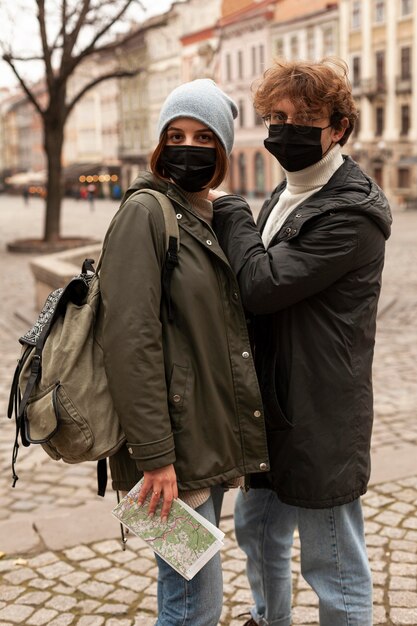 Young couple posing outdoors with medical masks