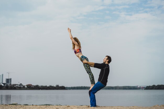 young couple practicing yoga on city background