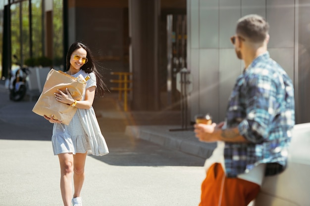 Young couple preparing for vacation trip on the car in sunny day. Woman and man shopping and ready for going to sea, riverside or ocean.