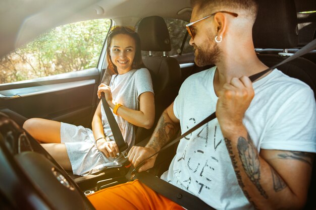 Young couple preparing for vacation trip on the car in sunny day.