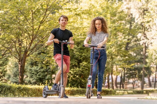 Young couple riding scooters outdoors