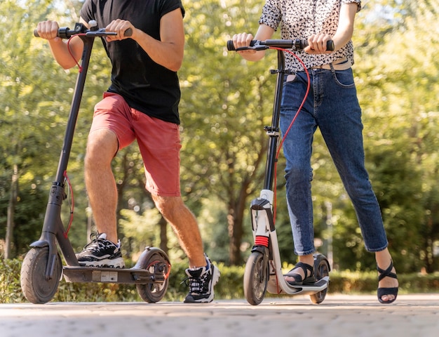 Free Photo young couple riding scooters outdoors