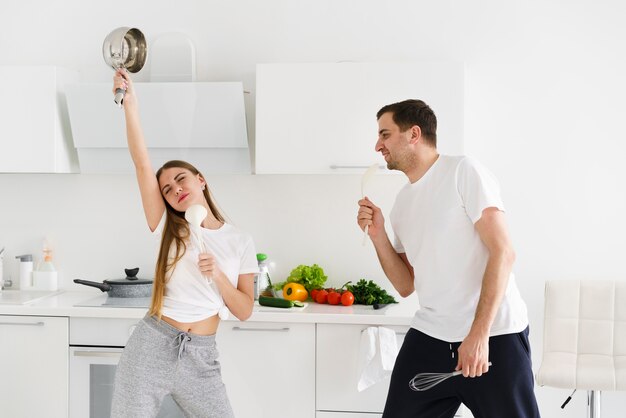 Young couple singing while cooking