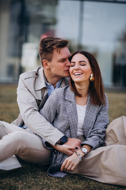 Young couple sitting on grass by the building