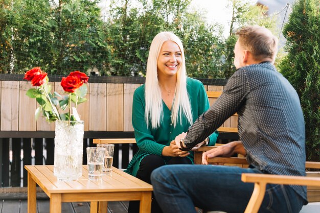 Young couple sitting in restaurant holding each other's hand