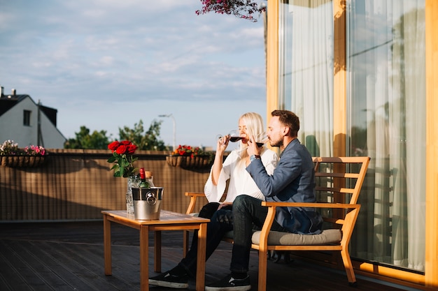 Free Photo young couple sitting in rooftop restaurant drinking wine