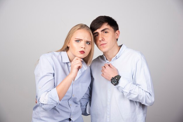 Young couple standing and looking at camera seriously