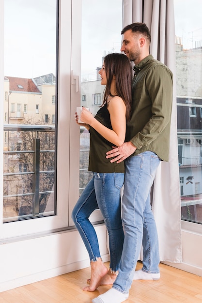 Young couple standing near the glass window