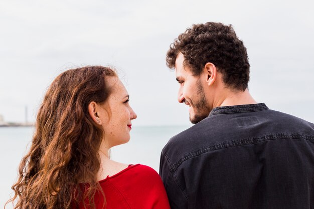 Young couple standing on sea shore 