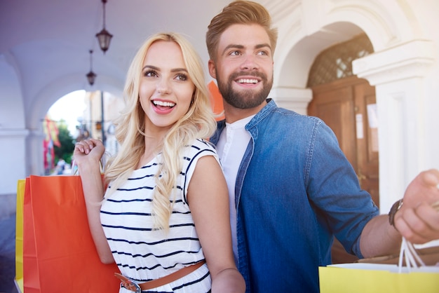 Free photo young couple standing with shopping bags