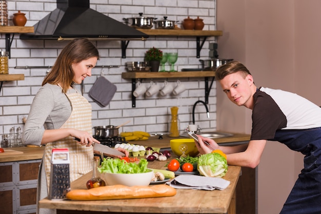 Free Photo young couple at table cooking in kitchen 