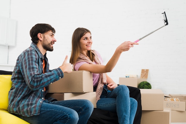 Young couple taking sulfide with smartphone in their new home