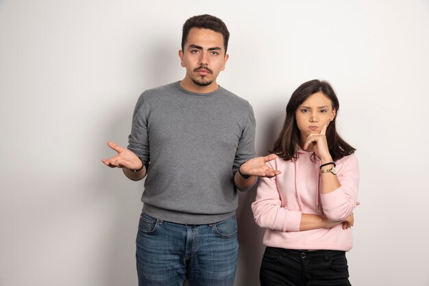 Young couple thinking on white.