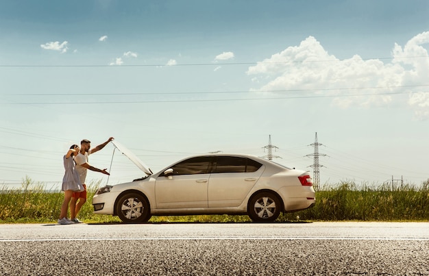 Young couple traveling on the car in sunny day