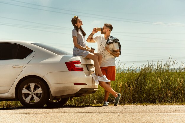 Young couple traveling on the car in sunny day