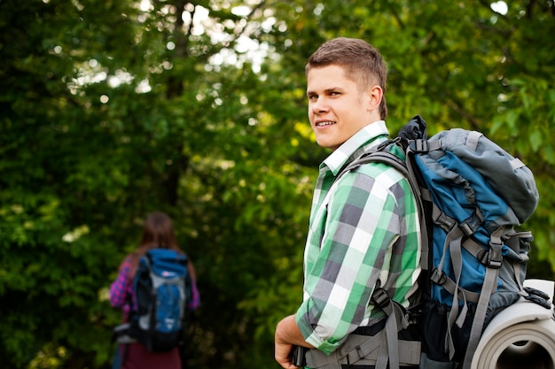 Free photo young couple walking through forest