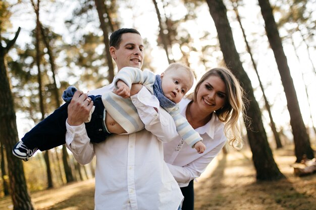 A young couple walks in the woods with a little boy