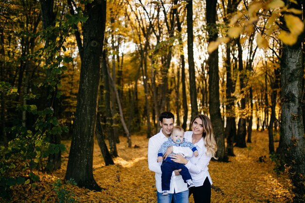 A young couple walks in the woods with a little boy