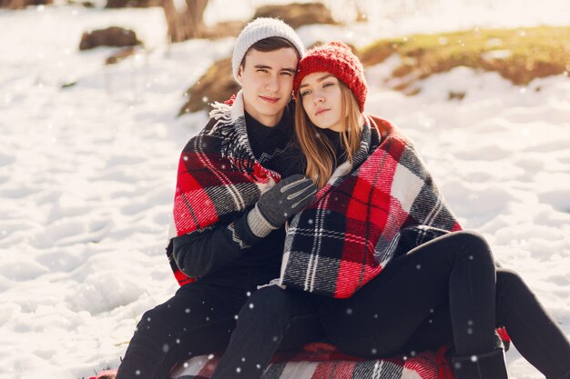 Young couple wearing blanket on a snowy field