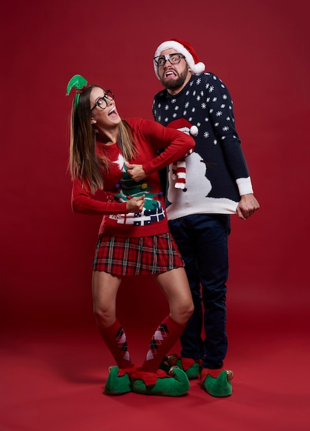 Young couple in weird Christmas clothes