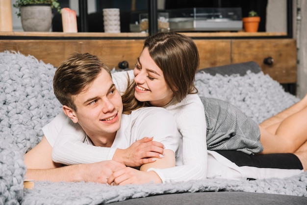 Young couple in white lying on couch