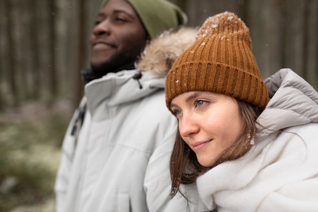 Young couple on a winter road trip together walking through the forest