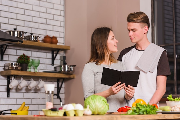 Young couple with notepad in kitchen