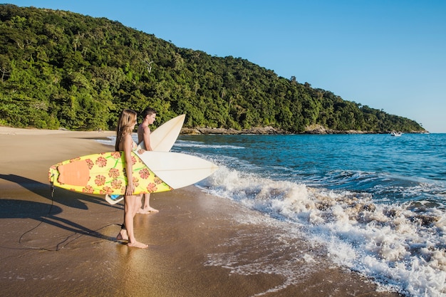 Free Photo young couple with surfboards